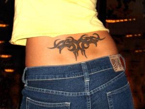 Tattoo (Arschgeweih) auf dem Rücken einer Frau