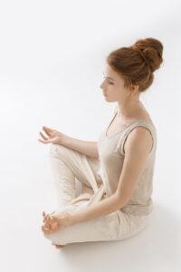 Mädchen praktiziert Yoga auf weißem Hintergrund