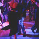 Paare tanzen traditionellen lateinischen argentinischen Tanz milonga im Ballsaal auf einem Festival, Tango-Studio, Salsa, Bachata und Kizomba Lektion in der roten und lila Lichter, Probe in Tanzkurs