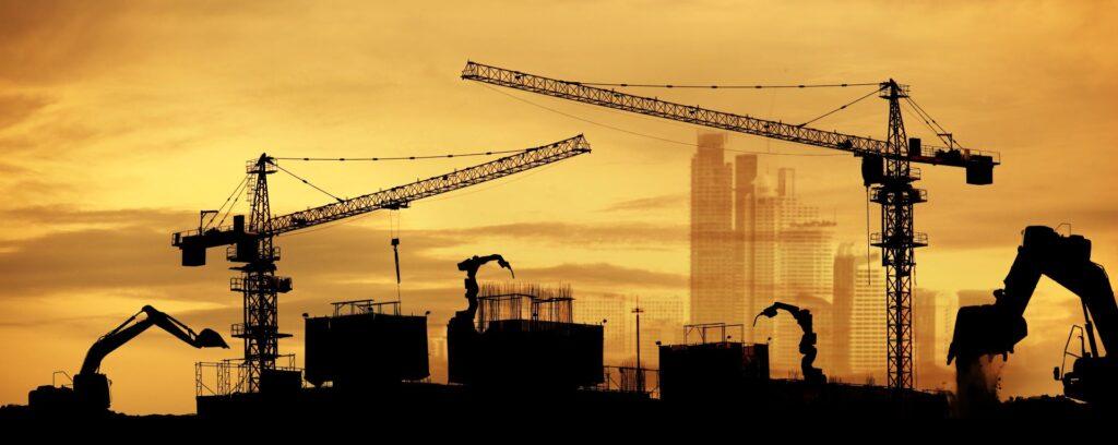 Baustelle mit Kränen und Elektrokettenzug im Abendlicht