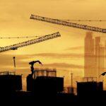 Baustelle mit Kränen und Elektrokettenzug im Abendlicht